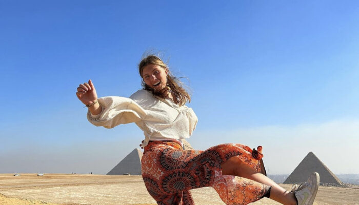 Girl dancing in front of pyramid